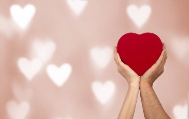 Couples holding heart shaped gift box with bokeh background. Love, gift and present concept.