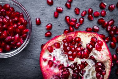 Koyu arkaplanda taze nar tohumları ve sulu nar meyvesinin ayrıntıları..