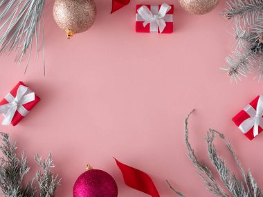 Noel düz kompozisyonu, hediye kutuları ve pastel pembe arka planda Noel dekoru. Noel, kış, yeni yıl konsepti. Üst görünüm, alanı kopyala