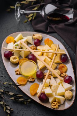 Cheese platter with organic cheeses, fruits, nuts and wine