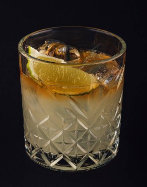 Yellow drink with lime on dark background