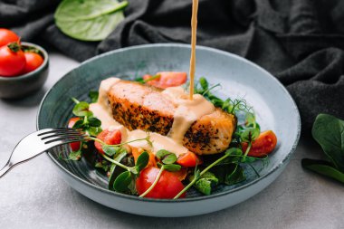 Grilled salmon with vegetables and sour cream sauce