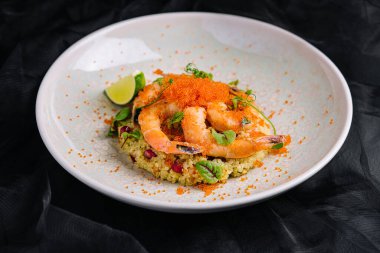 Kırmızı havyar altında karides ve sebzeli kuskus.