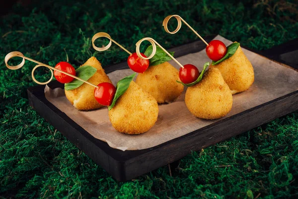 Tasty cheese balls pear-shaped with tomatoes