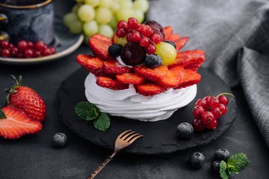 Taze böğürtlenlerle süslenmiş mini pavlova kremalı pasta.