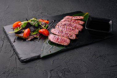 Dilimlenmiş az pişmiş biftek parçaları.