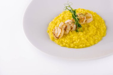 Kızarmış deniz tarağı ve beyaz tabakta mısır.