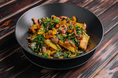 Siyah tabakta mantarlı kızarmış patates.