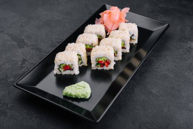 Siyah tabakta susamlı vejetaryen suşi maki ruloları.