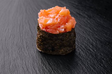 Siyah ahşap arka planda somon balığı olan Gunkan