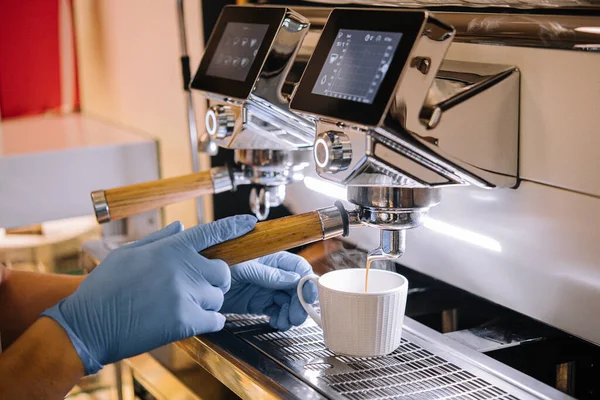 Professional coffee machine with white cup and pouring drink