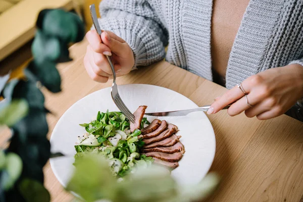 Kadın restoranda Vitello Tonnato yiyor.