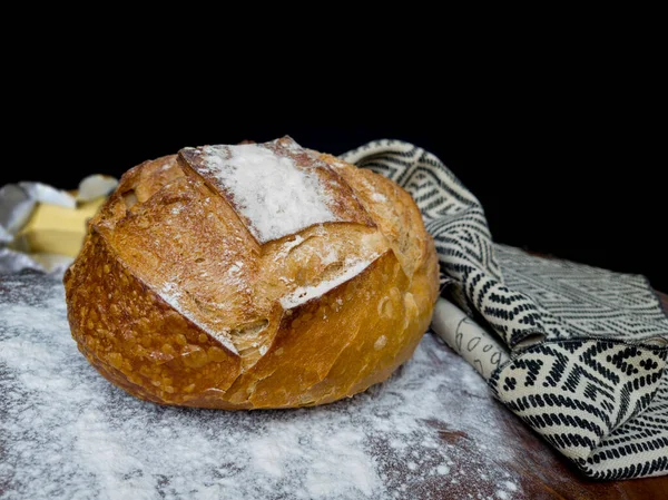 Italian bread and butter with cloth with African illustration on wood with white flour and black background