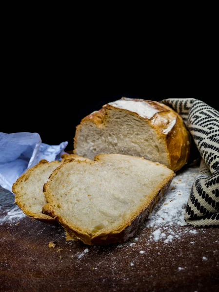 Italian bread with cloth with African illustration over wood and white flour with black background and copy space.