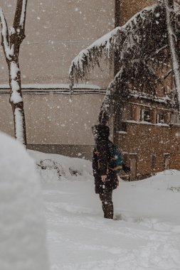 snowfall in madrid with a man standing watching the snowflakes fall