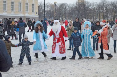 Saint-Petersburg.Ocak 03. 2022 'de Palace Meydanı' nda yeni yıl şenlikleri var. Noel Baba çocuklara hediye veriyor. İnsanlar dans eder, eğlenir, dans eder..