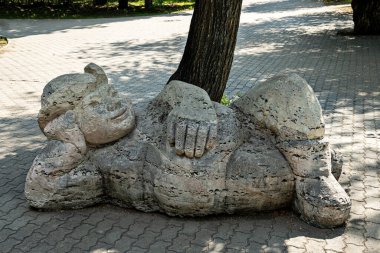 a sculpture of a man who is tired from work and decides to rest under a tree