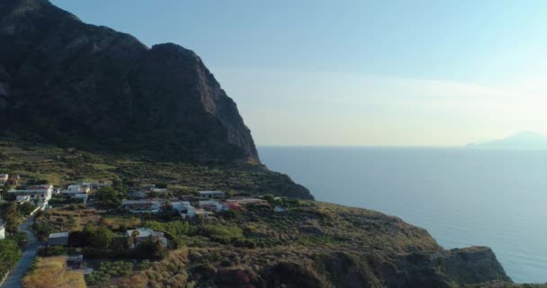 석양이 지는 동안 파노라마같고 그림같은 바위가 많은 해안선 과푸른 들판, 나무, 그리고 작은 마을 이 있다. 여름 여행으로 시칠리아 해안을 공중에서 내려다본 모습. — 비디오
