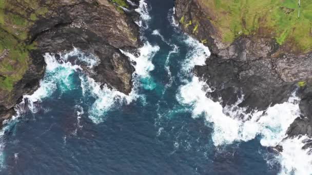 Εναέρια άποψη των κυμάτων σπάσει στα βράχια των νησιών Φερόε βράχια σε ένα μπλε ωκεανό.Drone Εναέρια Πλάνα της πράσινης φύσης και του ωκεανού. — Αρχείο Βίντεο