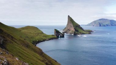 Körfez manzaralı dağ manzarası, mavi okyanus, yeşil çayır, yüksek uçurum. Faroe Adaları 'nda vahşi yaşam, insan yok, mavi okyanuslu dağ manzarası. Görkemli manzara Yeşil dağ ve deniz