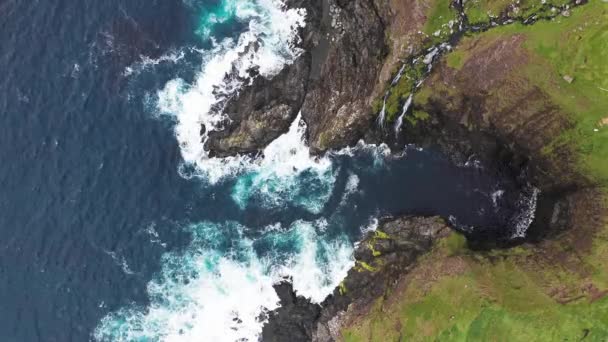 Luchtfoto van golven breken op rotsen van Faeröer eilanden kliffen in een blauwe oceaan.Drone Luchtfoto Beelden van groene natuur en de oceaan. — Stockvideo