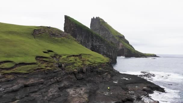 Faroe Adaları 'ndaki Rocky Drangarnir deniz yığını ve skarosafossur Şelalesi' nin hava manzarası. Güzel, el değmemiş doğa, pürüzsüz deniz, kaya kayalıkları, dalgalar deniz köpüğü, gökyüzünde bulutlar oluşturur. — Stok video