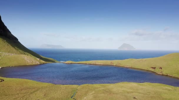 Luchtfoto van klif bedekt met gras, blauwe zee, zon, wolken — Stockvideo