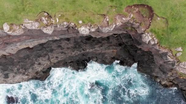 Vista aérea de altos acantilados rocosos, olas del océano rompen en acantilados. Naturaleza salvaje, vida silvestre, silvestre no hay gente, nubes en el cielo, paisaje sin precedentes — Vídeos de Stock