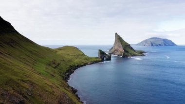 Körfez manzaralı dağ manzarası, mavi okyanus, yeşil çayır, yüksek uçurum. Faroe Adaları 'nda vahşi yaşam, insan yok, mavi okyanuslu dağ manzarası. Görkemli manzara Yeşil dağ ve deniz
