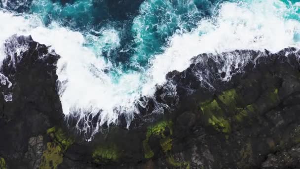 Aerial view of waves break on rocks of Faroe islands cliffs in a blue ocean.Drone Aerial Footage of green nature and the ocean. — Stock Video