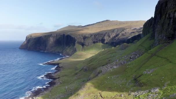Luftaufnahme riesiger Klippen auf den Färöer-Inseln, grüner felsiger Berg, mächtige Meereswellen, an einem bewölkten Sommertag, grüne Wiesen und Felsen in wilder Natur, wild kein Haus. — Stockvideo