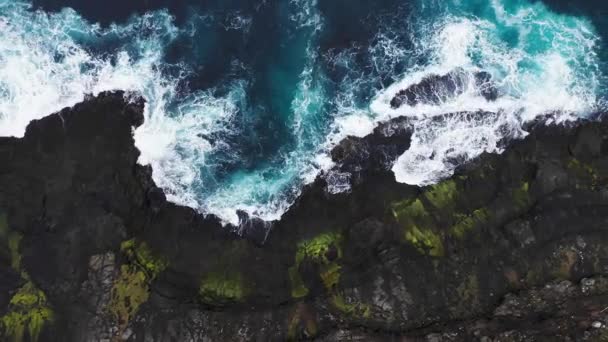 Vista aérea de las olas se rompen en las rocas de los acantilados de las Islas Feroe en un océano azul.Drone Imágenes aéreas de la naturaleza verde y el océano. — Vídeo de stock