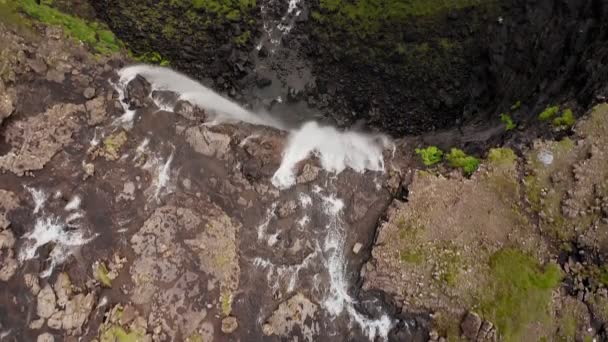 Uçurum manzarasından çarpıcı bir şelale fışkırıyor. Faroe Adaları 'ndaki Gasadalur Köyü yakınlarında Mulafossur şelalesi. İleriye dönük çekim, gün ışığı, bulutlu hava — Stok video
