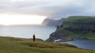 Yürüdükten sonra dinlenen insanın havadan görünüşü, sahil manzarası. Genç adam vahşi manzaraya, uçuruma, denize, güneş ışığına hayran..