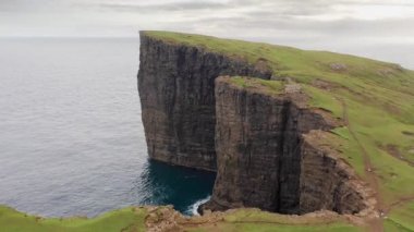 Serinin bir parçası, Faroe Adaları 'ndaki ünlü uçurumun havadan görünüşü. Bulutlu bir günde yeşil çimenler ve uçurumun toprak yolu üzerinde uçmak..
