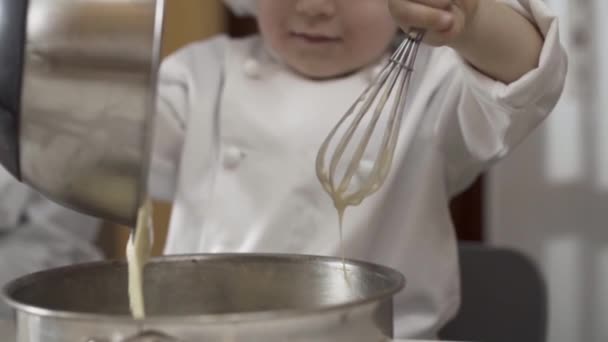 Detailní záběr rukou mladého šéfkuchaře přenese těsto do plechovky na dort. Houba koláč těsto před vařené zpomalený film — Stock video