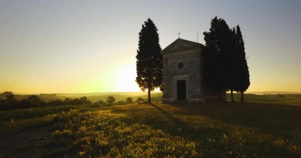 Vista aérea da igreja abandonada na Toscana durante o pôr do sol. Luz dourada do sol brilhando no campo. — Vídeo de Stock