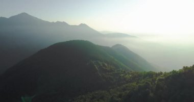 Sisli ormanın hava manzarası. Arkasında buzulun olduğu yeşil sıradağların insansız hava aracı bakış açısı. - Yeşil sürdürülebilir ulaşım gelecekteki konsepti. yavaş çekim