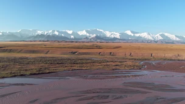 日落时的五彩斑斓的自然景观.背景为农田、紫色河流、黄沙、白雪覆盖的山脉背景、宁静的日子. — 图库视频影像