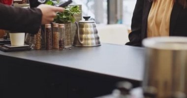 PIN kodunu girmeden kredi kartı ödeyen kadının yakın plan fotoğrafı, akıllı ödeme, ulaşılamaz ödeme, e-para, dijital para. Tıbbi maskeli barmen kadın, Cavid 'den sonra iş tekrar açıldı.