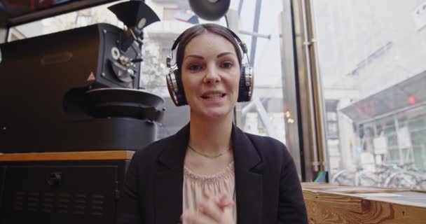 Porträt einer jungen kaukasischen Geschäftsfrau, die mit der Webcam spricht, macht Videotelefonie in einem Coffeeshop, indem sie sich per virtueller Videotelefonie-App mit einem Online-Videokonferenzgespräch unterhält. Webkamerabilder — Stockvideo