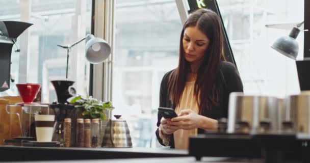 Πελάτισσα γυναίκα που πληρώνει χρησιμοποιώντας την τεχνολογία NFC με τηλέφωνο και πιστωτική κάρτα, ανέπαφη πληρωμή με μαθήτρια κορίτσι.Πληρωμή μέσω τηλεφώνου σε ηλεκτρονικό μηχάνημα πληρωμής ή αναγνώστη καρτών. Ηλεκτρονικό χρήμα στο πορτοφόλι χωρίς μετρητά — Αρχείο Βίντεο