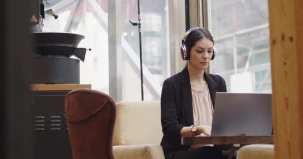 Καυκάσια επιχειρηματίας συνδέεται με ένα βίντεο συνέδριο σε μια καφετέρια. Front view of young woman talking in a virtual conference with her συναδέλφους, εξ αποστάσεως εργασίας και αποτελεσματική έννοια της εργασίας — Αρχείο Βίντεο