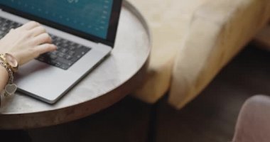 Bir kafede oturup dizüstü bilgisayarla çalışan, cep telefonuyla ödeme yapan, akıllı ödemeler yapan, irtibatsız ödemeler yapan, e-para, dijital para alan bir kadının detayları. Bilgisayarı kapattıktan sonra 
