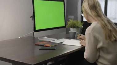 Üniversite öğrencisi internetten ders izliyor ve evden ders çalışıyor. Genç bir kadın bilgisayar ekranına bakarken video görüşmesinde profesörün matematik çalışmasını izliyor. Yeşil Ekran