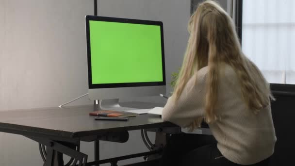 College student watching lesson online and studying from home. Young woman taking notes while looking at computer screen following professor doing math on video call. Green screen — Stock Video