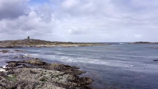 Aerial view of low tide seascape. Beautiful Drone point of view fly of irish coast line at low tide, green fields in the background lighthouse, calm sea in a cloudy day. — Stockvideo