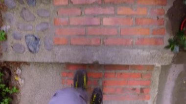 Erkek ayağı dışarıda yürüyor. Kamera sadece patika boyunca yürüyen adamın bacaklarını çeker. Şehirde gizli yerleri keşfetmek için yaz yolunda yürüyen bir turist.. 