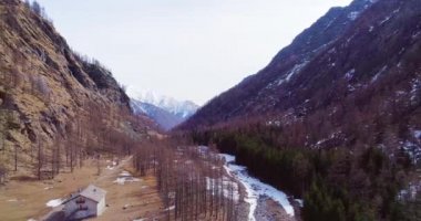 Sarı Dağ Vadisi 'ndeki derenin yakınındaki çadırdan geriye doğru hareket eden hava uçuşu ve orman ormanı yerleşkesi. Sonbaharda kar yağışı sonbaharda veya kışın insansız hava aracı oluşturan vahşi doğa manzarası.