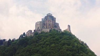 Dağın tepesindeki bir kilisenin manzarası. Dağlık yamaçlarda uzanan yoğun orman. Bulutlu bir gün. Yüksek kalite 4k görüntü